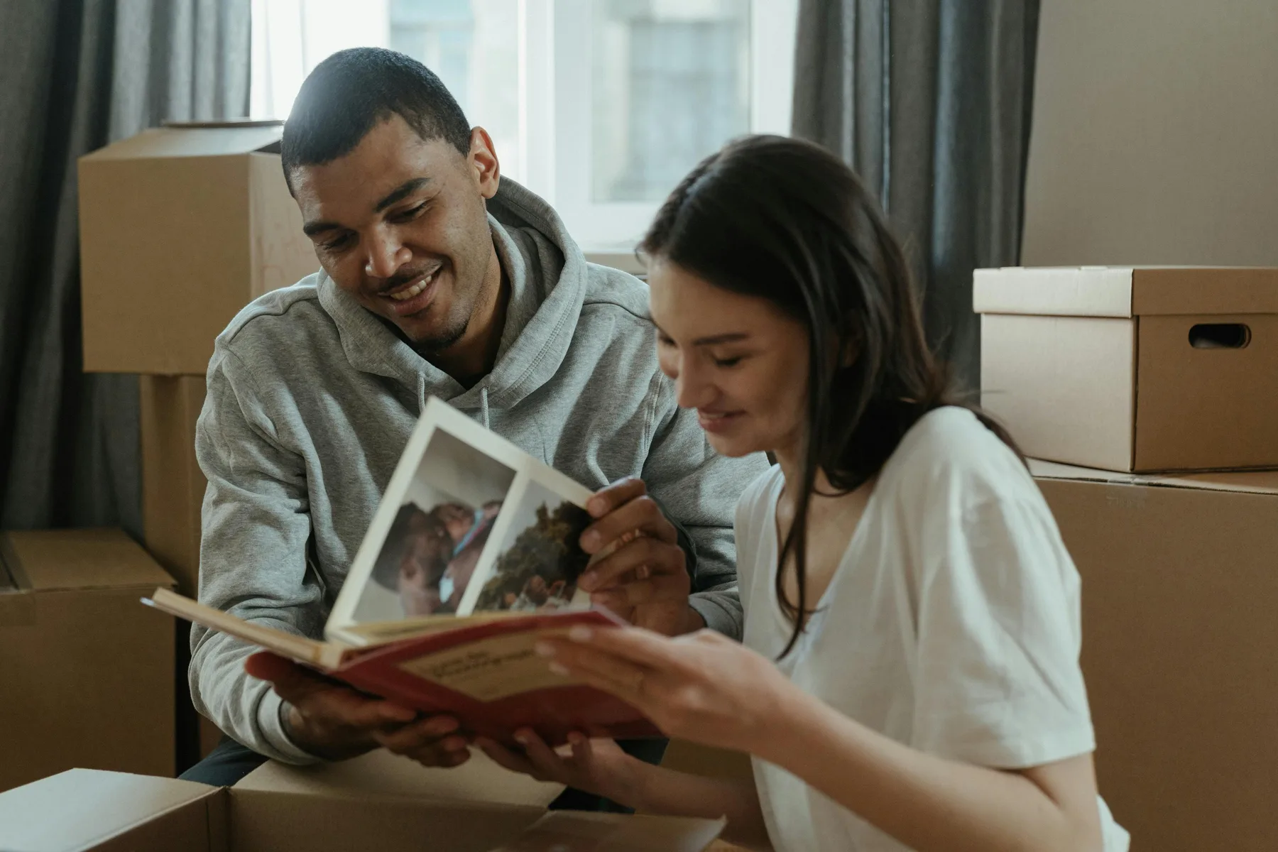 A young couple sitting together looking through a photo book