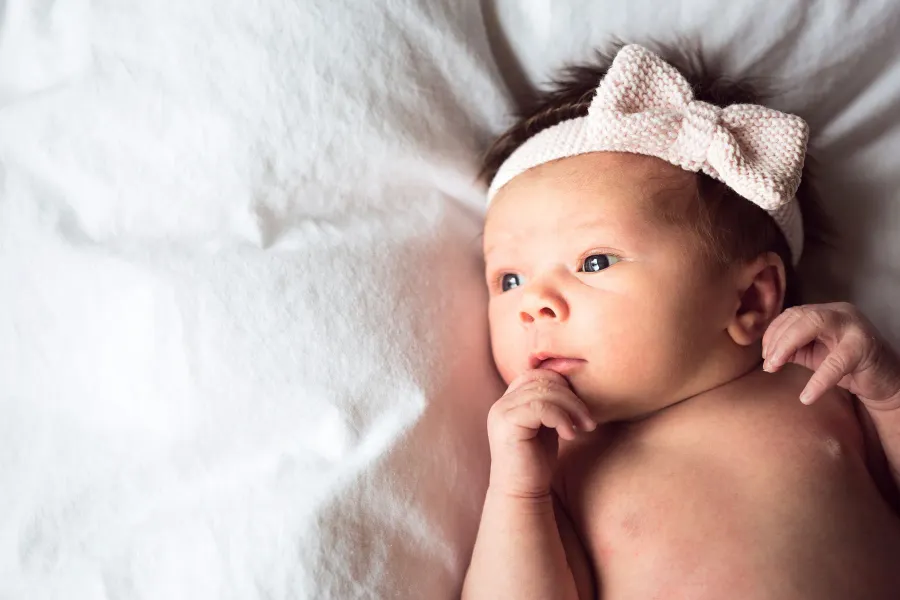 A newborn in a bow headband