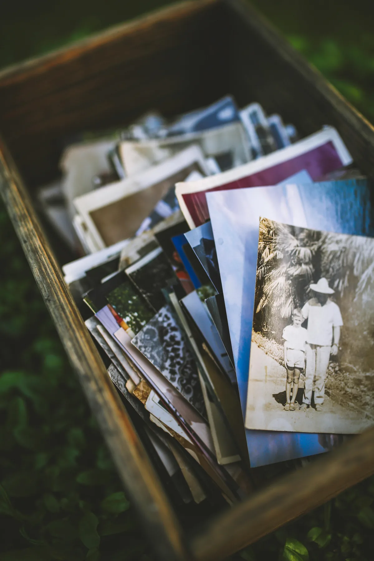 A box of loose family photographs, including an old black-and-white portrait