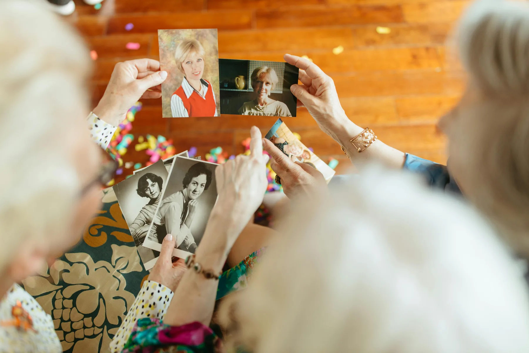 A group of people passing old photographs between them around a table